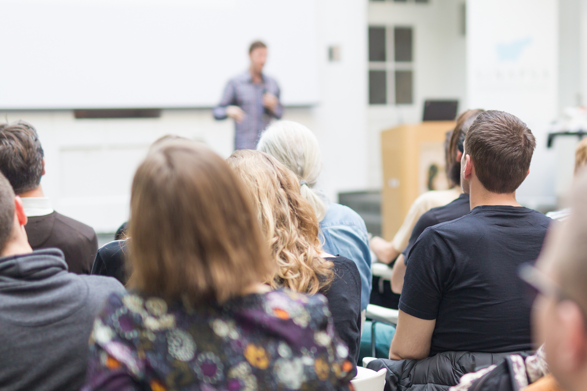 Male,Speaker,Giving,Presentation,In,Lecture,Hall,At,University,Workshop.